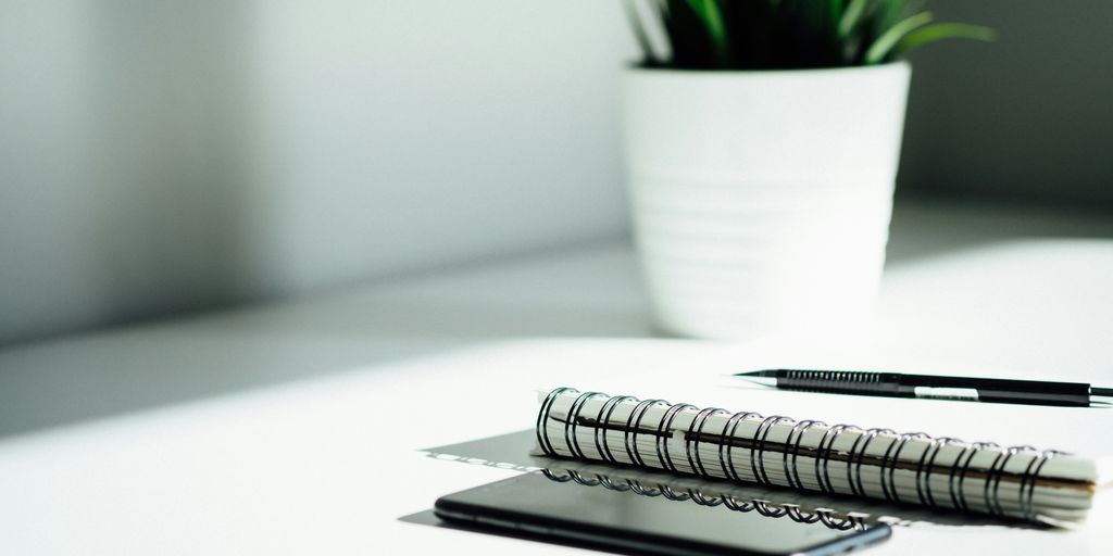 pen, notebook, and smartphone on table