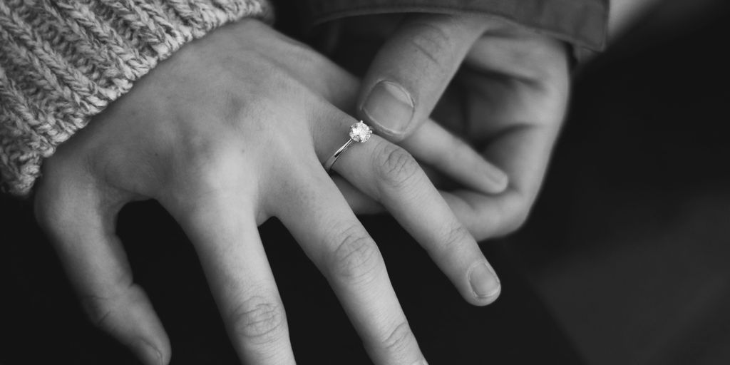 woman wearing wedding ring with man holding hand